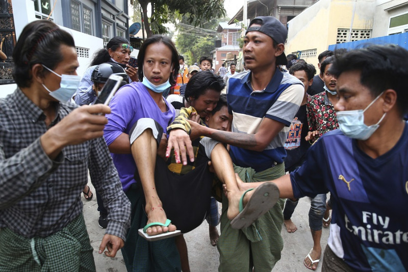 20日，緬甸安全部隊使用水槍，催淚瓦斯，彈弓和子彈對付示威者，一名受傷男子被抬離現場。   圖：達志影像/美聯社