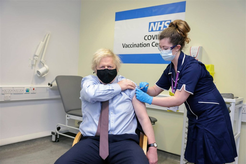 英國施打2019冠狀病毒疾病疫苗達成新里程碑，境內超過半數成人已施打至少一劑疫苗。圖為英國首相強生（左）19日施打阿斯特捷利康疫苗。（圖取自facebook.com/borisjohnson）   