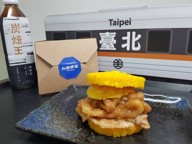 以醃製軟嫩、鹹香撲鼻的燒肉，搭配甘甜解膩的鳳梨製作出的「薑黃燒肉米堡」   圖：台北鐵路餐廳／提供