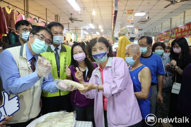 台南市長黃偉哲（左）前往虎尾寮市場，了解攤商如何用當季新鮮蔬果取代砂糖做出「鳳梨鮮蔬果潤餅」，並將現包現做的潤餅也發送給民眾及社區長者。   圖：黃博郎／攝
