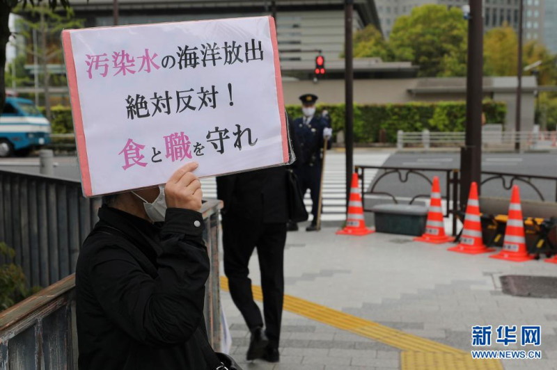 日本民眾舉牌反對核廢水入海。   圖：新華社