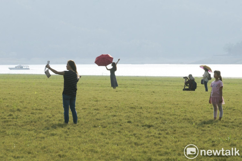 遊客們在「日月潭大草原」拍紀念照。   圖：張良一/攝