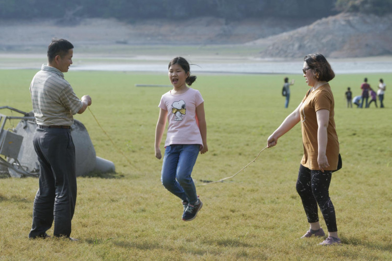 小朋友和她的家人在日月潭大草原玩跳繩。   圖：張良一/攝