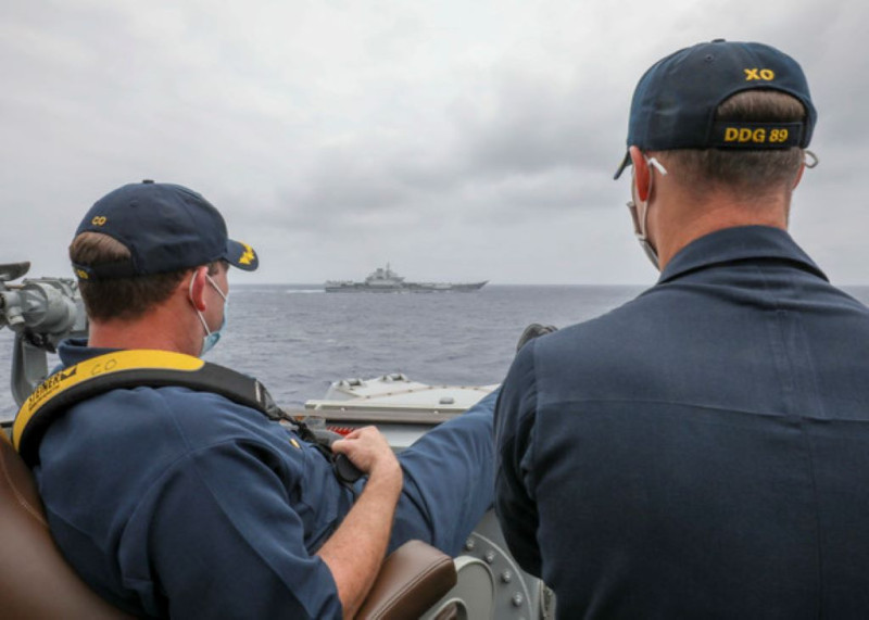 美軍日前公開，「馬斯廷號」（USS Mustin）艦長與副艦長在船上觀察中國航空母艦「遼寧號」的翹腳照，引起外界爭議。   圖：翻攝自美國海軍官網
