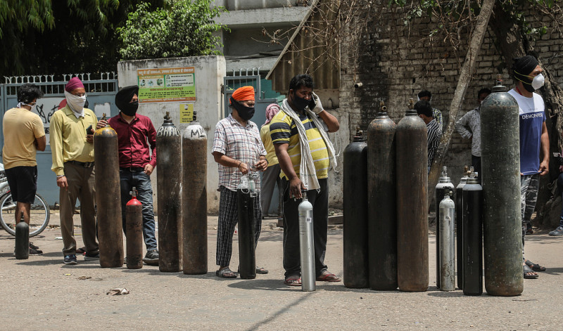 新冠肺炎疫情失控，印度民眾排隊等待領取氧氣瓶。   圖 : 翻攝自海外網