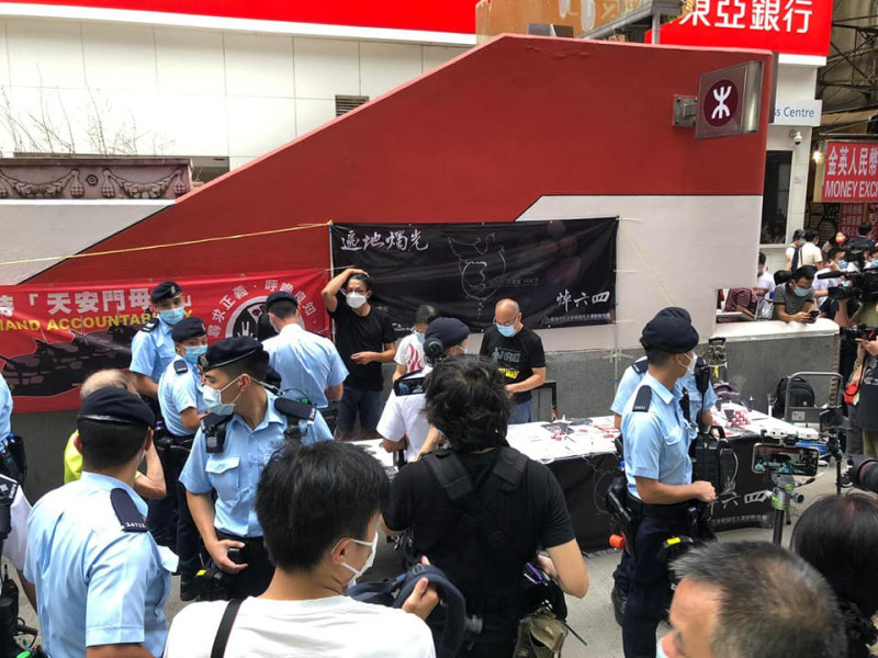 軍裝員警搜查香港支聯會攤位，指有人報案非法募款。   圖：翻攝香港支聯會 Hong Kong Alliance臉書