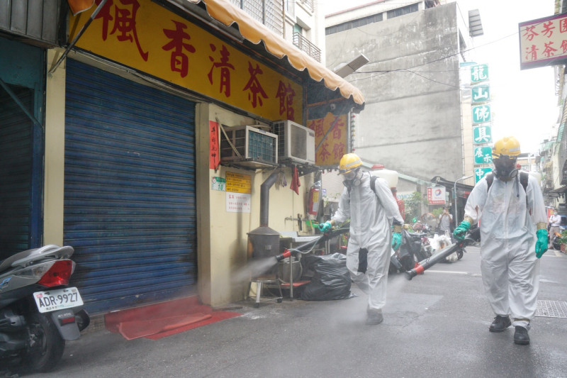 傳出確診案例的楓香清茶館已拉下鐵門暫停營業，而市府衛生局也派員在店外消毒。   圖：張良一/攝