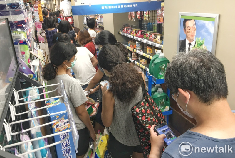 雙北警戒升級後，超市內擠滿了搶購各種民生物資的民眾。   圖：張良一/攝