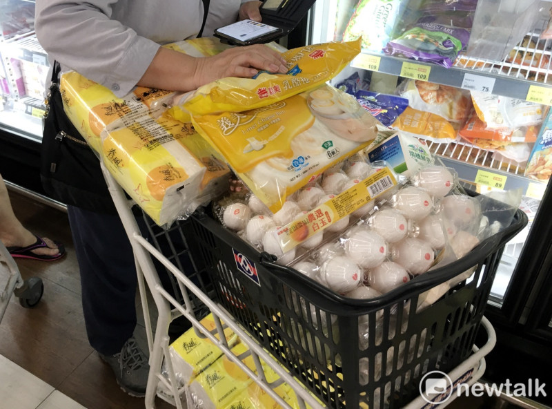 一位民眾的購物車堆滿了雞蛋、乳酪卷和衛生紙等民生用品。   圖：張良一/攝