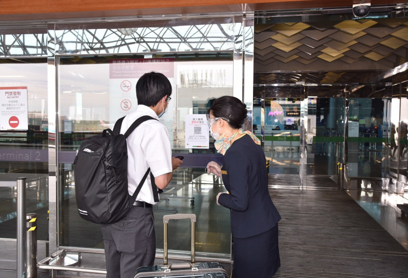 機場服務台人員協助出境旅客使用手機簡訊實聯登記進入航廈。   圖：桃機／提供