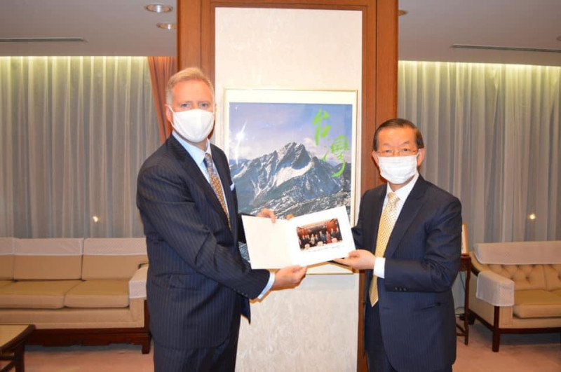 謝長廷與美國駐日本大使館代辦Joseph Young在台灣最高山玉山的照片前合影，照片上還有大大的綠色「台灣」兩字。   圖：翻攝謝長廷臉書