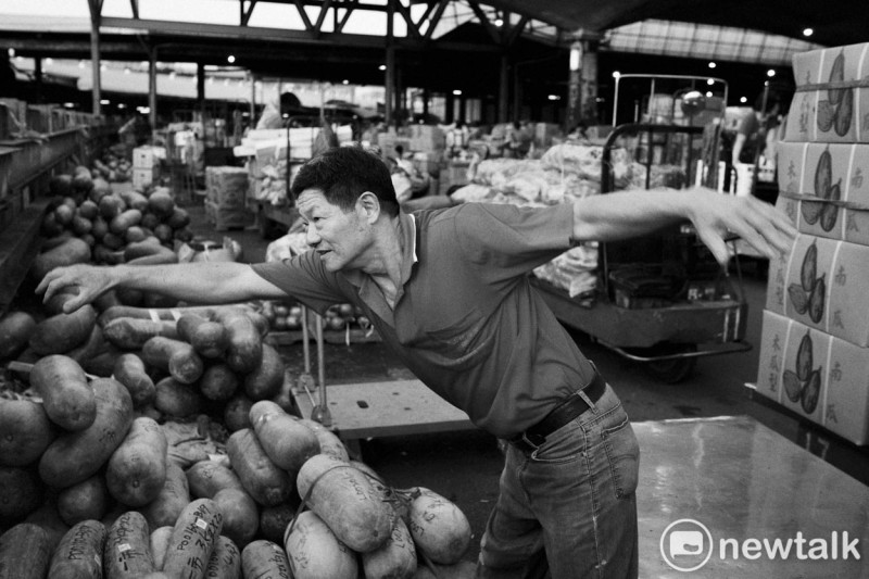 一位蔬果承銷業者清晨買完蔬果後，在北農一市拍賣場外運動健身。照片攝於北農一市，2018年。   圖：張良一/攝