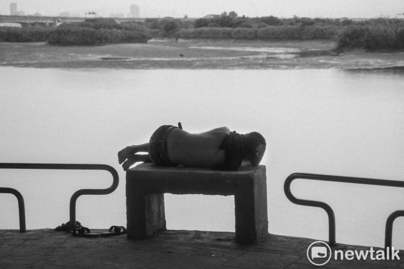 一位市民在萬華華江河濱公園的河堤睡午覺。照片攝於2017年。萬華華江河濱公園。   圖：張良一/攝