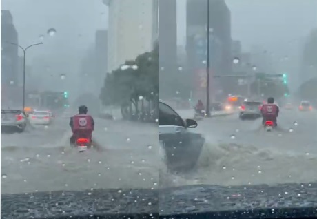 外送員頂著大雷雨以及道路淹水，騎在滾滾黃流中，畫面險象環生。   圖:翻攝畫面