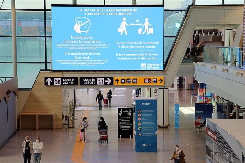 為防範變種病毒，義大利與比利時皆宣布英國入境旅客需隔離。圖為羅馬費烏米奇諾機場防疫宣導標語。   圖取自facebook.com/AeroportiDiRomaFiumicinoCiampino