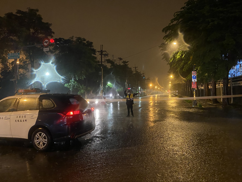 高雄市25日晚間傾盆大雨，多處累積雨量逾100毫米，小港區中林路更因淹水一度造成9車10人受困，轄區林園警分局員警獲報到場指揮交通救援。   圖：林園警分局提供
