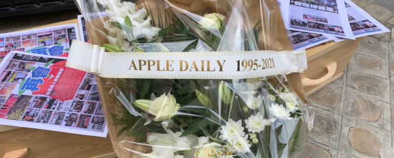 巴黎無國界記者組織代表25日乘坐靈車抵達中國大使館，將棺材和鮮花送至現場，以模擬葬禮的方式抗議，上面的標語牌寫著「蘋果日報（1995－2021）」。   圖/RSF官網