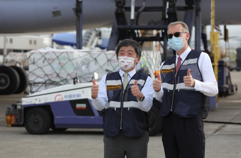 衛福部長陳時中(左)和AIT處長酈英傑(右)一同迎接250萬劑莫德納疫苗的到來。      圖：指揮中心／提供