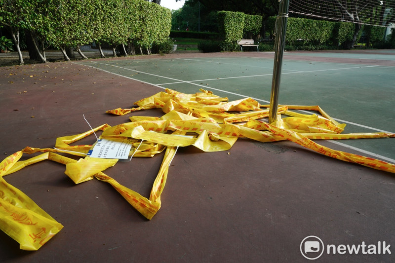 疫情三級警戒微解封首日，到青年公園羽球場打球的民眾一早就把綁在球架上的黃色警戒線通通拆下。   圖：張良一/攝