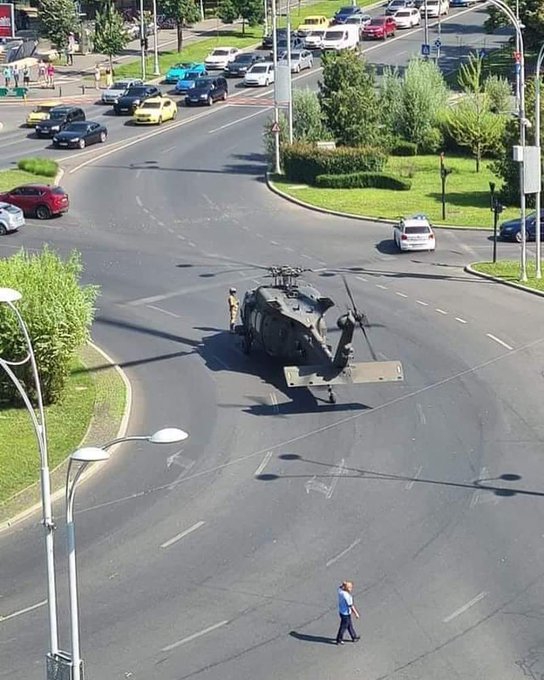 一架美軍「UH-60黑鷹」直升機，在羅馬尼亞時間15日發生迫降狀況，地點是羅馬尼亞首都布加勒斯特市戴高樂廣場；據傳下降時扯到2根電桿，導致2輛汽車受損，所幸沒有造成人員受傷。   圖：翻攝新華網