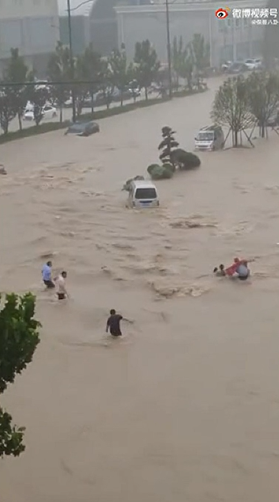 民眾直接在路上被大水沖走，附近民眾趕緊救援。   圖：翻攝微博