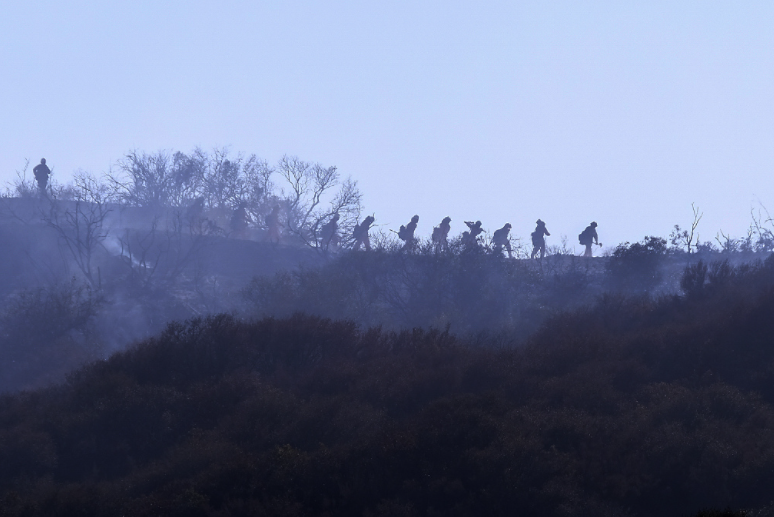 煙霧籠罩下的加利福尼亞州山火救援人員。   圖：翻攝自環球網