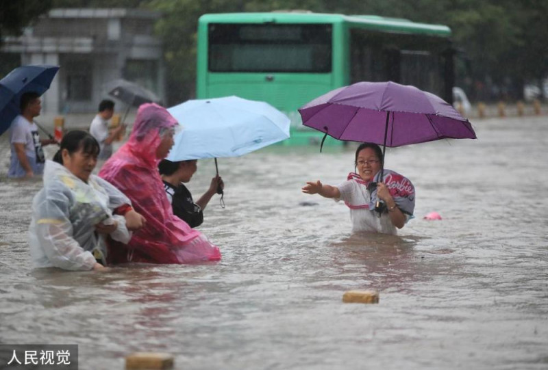鄭州街道變成河流，許多民眾泡在水裡。   圖 : 翻攝自人民視覺（資料照片）