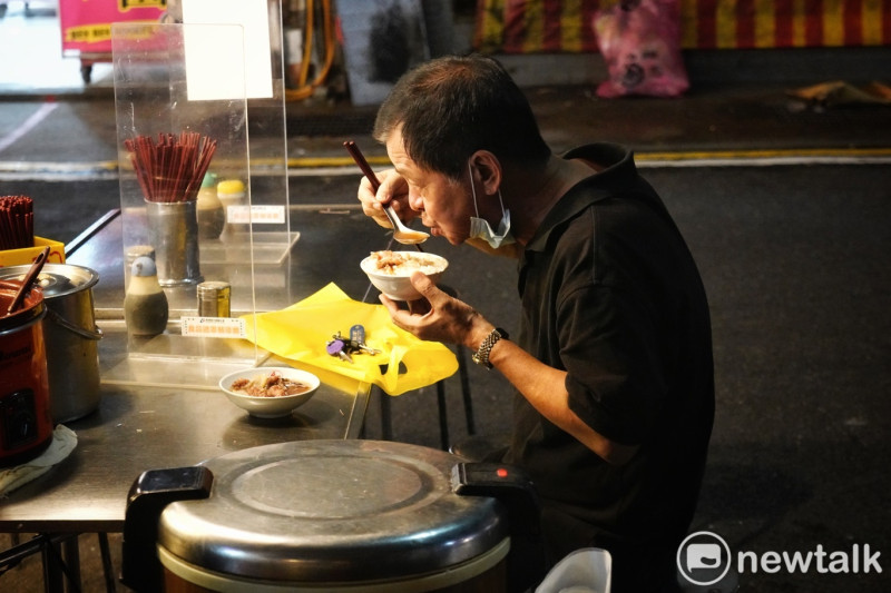 一位市民在鰻魚羹攤子享受鰻魚羹和滷肉飯美食。   圖：張良一/攝