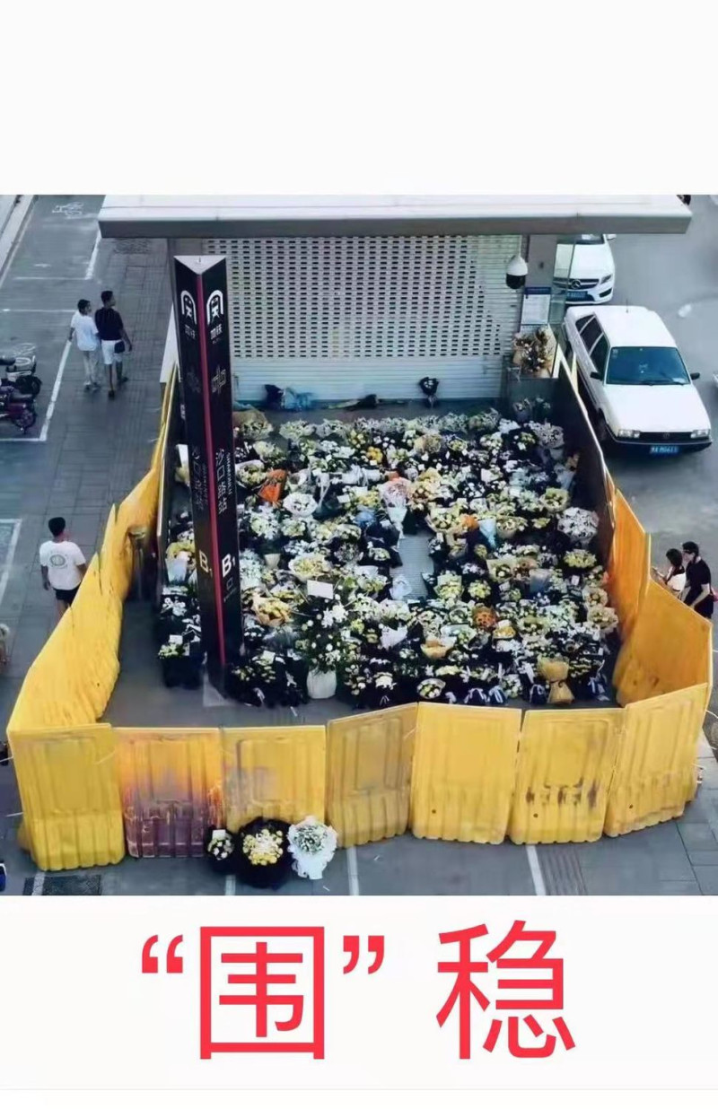 中國鄭州地鐵5號線站入口前，擺滿民眾悼念鮮花，突然在27日遭到地方政府以比人高的黃色塑膠隔板隔開，還清除了部分民眾的獻花，引起公憤。   圖：翻攝自ZHANGDONG推特