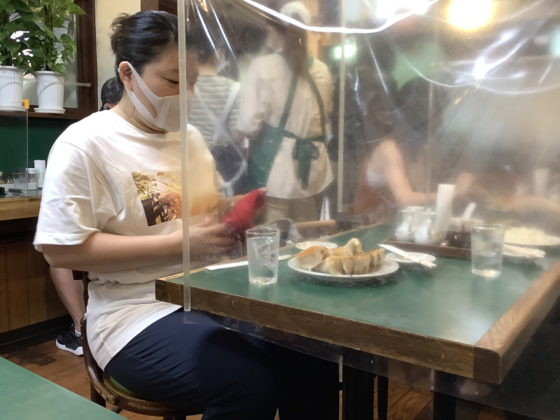 日本防疫，再擁擠的小店也設法拚命隔開，戴口罩，以免飛沫傳染。   圖：劉黎兒攝