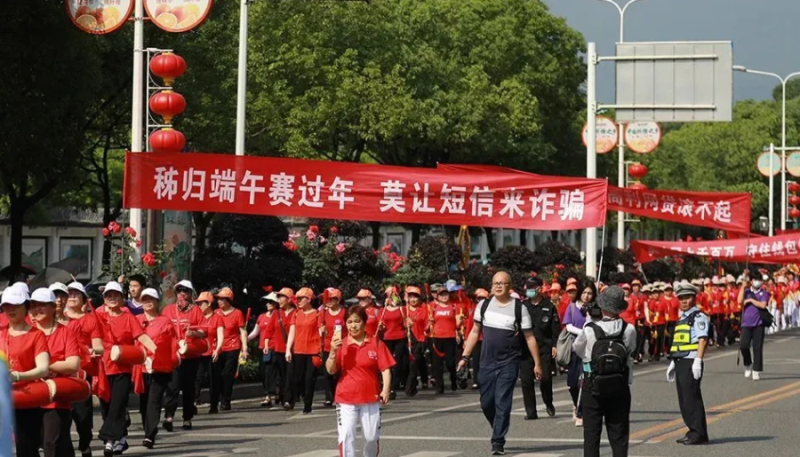 針對詐騙行動，2021年6月11日，在湖北省宜昌市秭歸縣非遺進景區的反詐騙隊伍中，志願者手舉橫幅沿途進行反電詐宣傳。   圖：翻攝自視覺中國