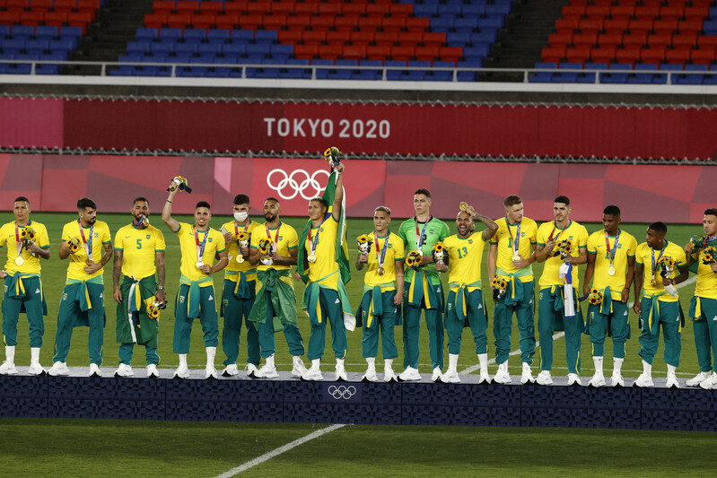 巴西男足成功衛冕奪金，在頒獎典禮時卻拒絕穿上贊助商「中國匹克」的運動服，而是將其綁在腰上。   圖：達志影像/美聯社