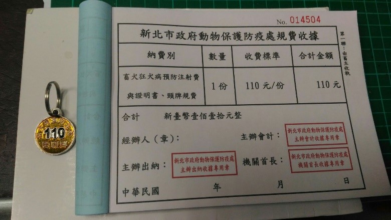 狂犬病疫苗注射後，動保處開立正式收據及給予今年度(110年)金色疫苗注射證明犬牌。   圖：新北市動保處提供