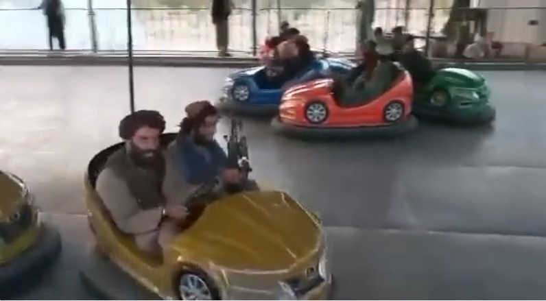 塔利班「神學士」在喀布爾的遊樂園內大玩碰碰車，手上仍拿著槍。   圖:翻攝自Hamid Shalizi推特