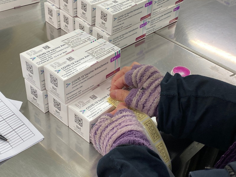 AZ疫苗封緘作業中，工作人員黏貼藥物檢查證。   圖：食藥署/提供