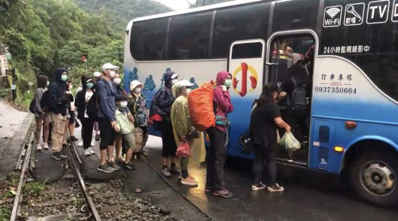 阿里山森林鐵路今天下午因邊坡土石滑落，造成交通受阻，林鐵處派巴士將旅客接駁下山。   圖：林鐵處/提供