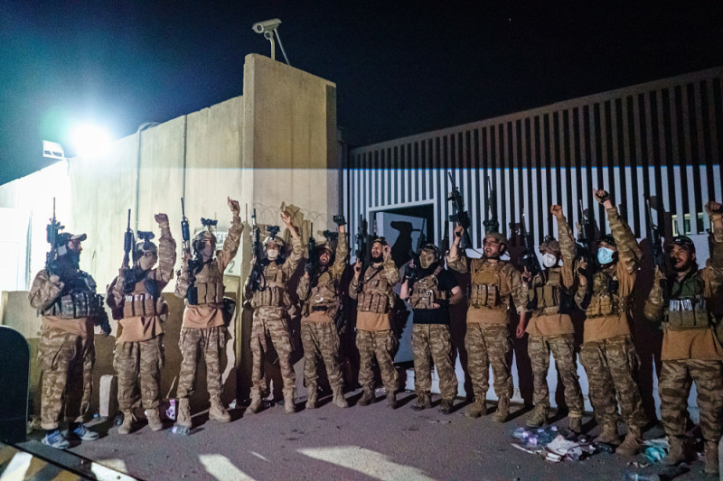 塔利班部隊在喀布爾機場門口鳴槍慶祝美軍離開，並高呼口號。   圖 : 翻攝自視覺中國