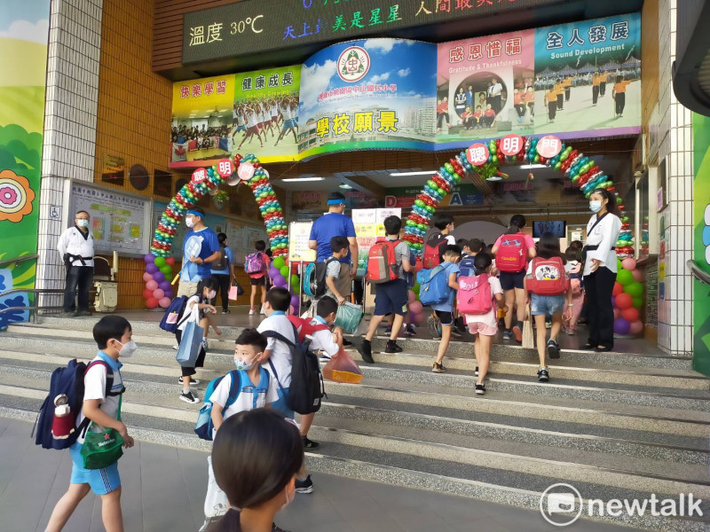 開學首日，桃園校方安排「防疫門」迎新，老師及志工在校門口迎接新、舊生返校上課。   圖：林昀真／攝