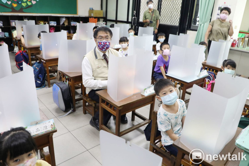 台南市長黃偉哲視察開學日防疫措施時，特別坐在學生座位，體驗如何使用防疫隔板。   圖：台南市政府提供