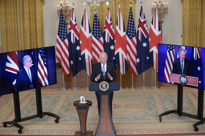 美國總統拜登（中）與英國首相強生（右螢幕）、澳洲總理莫里森（左螢幕）15日共同召開記者會，宣布成立AUKUS聯盟，應對印太區域威脅。   圖：達志影像/美聯社