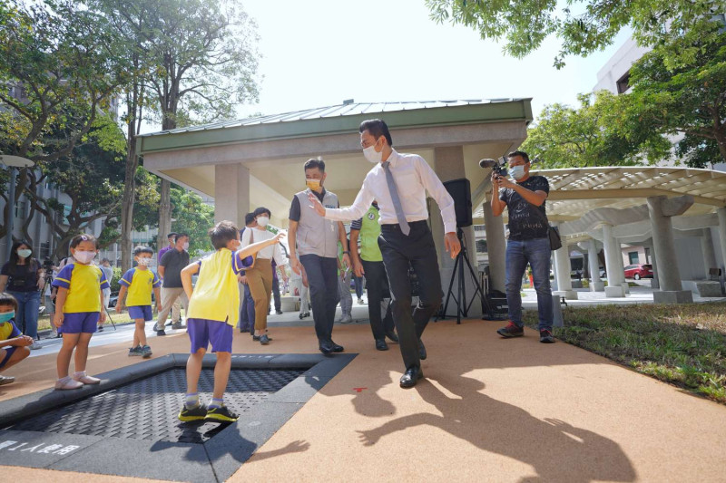 新竹市長林智堅今(16)日在興南公園與孩童體驗親子鞦韆、彈簧網等公園設施，並擊掌互動。   圖:新竹市政府提供。