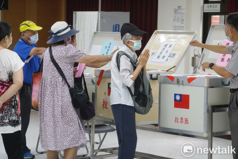 一位老黨員投完票後，雙手合十向投票所的工作人員致意。   圖：張良一/攝