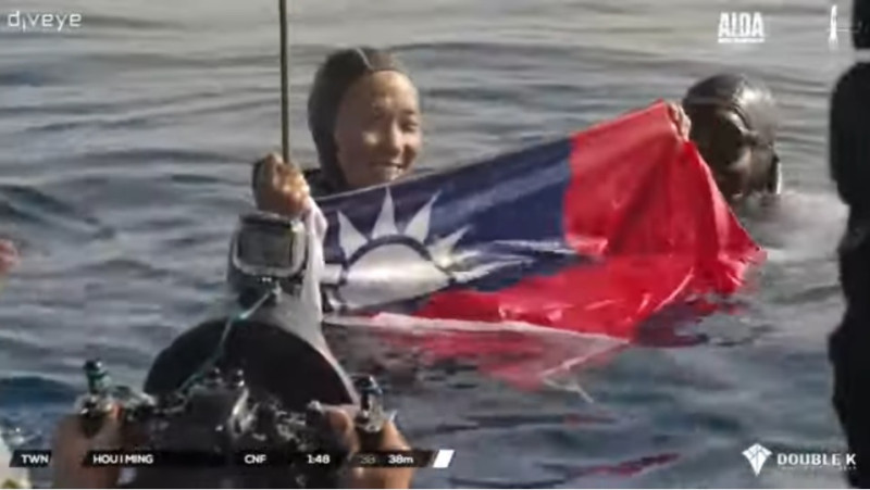 參加AIDA自由潛水世界錦標賽的我國選手侯一明，在賽後秀出國旗，眾國際友人都幫她歡呼。   圖：翻攝自YouTube/AIDA