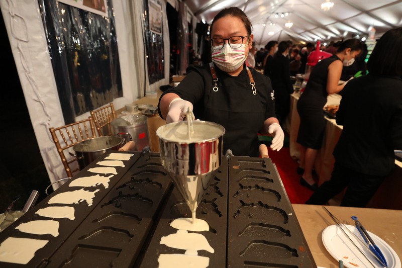 雙橡園主廚高于婷（前）6日晚間在雙橡園國慶晚會製作熱騰騰雞蛋糕，把台灣街頭體驗搬到華府。 圖：中央社提供