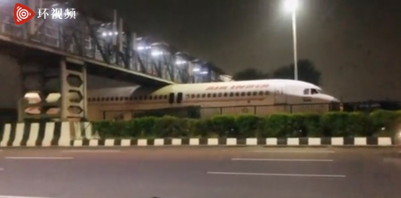 印度一架飛機「卡」在天橋下。   圖：翻攝自環球網