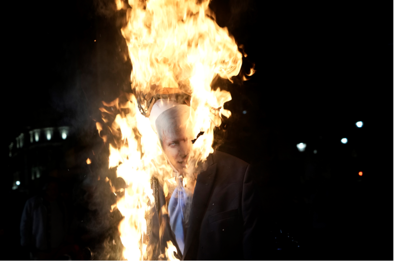 抗議者焚燒首相強生的雕像。   圖: 達志影像/美聯社