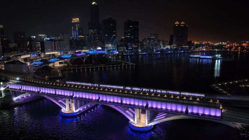 輕軌橋燈光優化升級，配合高流建築燈光變化形成愛河灣最美麗的夜景。   圖：高雄市政府／提供