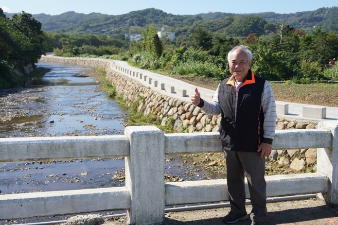 洪啟誠表示，完工後居民們困擾已久的問題沒了，還獲得了便利的聯外道路及更自然的風景環境。   圖：新北市水利局提供