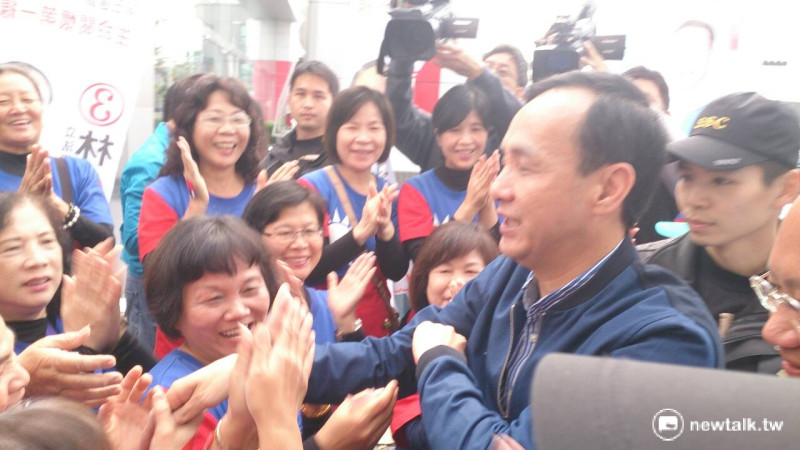國民黨總統候選人朱立倫10日上午抵達台南立委候選人林易煌競選總部，獲得20多位身穿國旗衣的「資深美少女」熱烈歡迎。   圖：邱珮文/攝