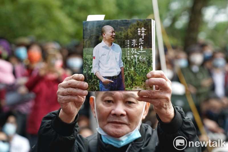 一位韓國瑜的支持者高舉韓國瑜的新書讓媒體記者拍照。   圖：張良一/攝